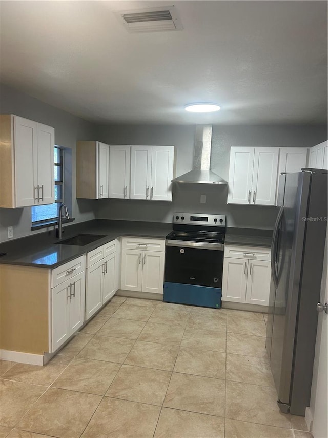 kitchen featuring white cabinets, a sink, visible vents, wall chimney range hood, and appliances with stainless steel finishes