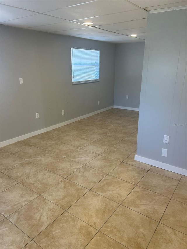 unfurnished room featuring a drop ceiling and baseboards