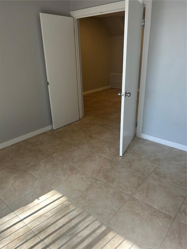 empty room featuring visible vents, baseboards, and light tile patterned flooring