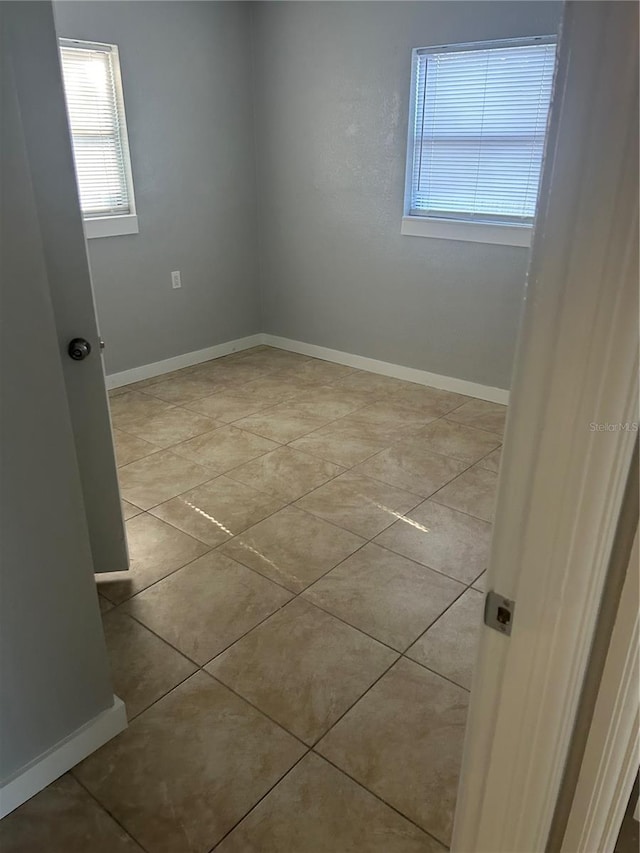 empty room featuring tile patterned flooring and baseboards