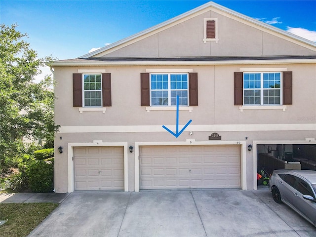 view of front of property with a garage, stucco siding, and concrete driveway
