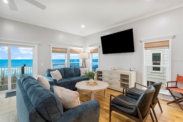 living room with a wealth of natural light, ceiling fan, and crown molding