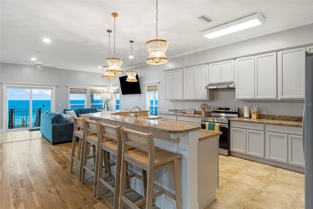 kitchen featuring visible vents, stainless steel appliances, under cabinet range hood, and a healthy amount of sunlight