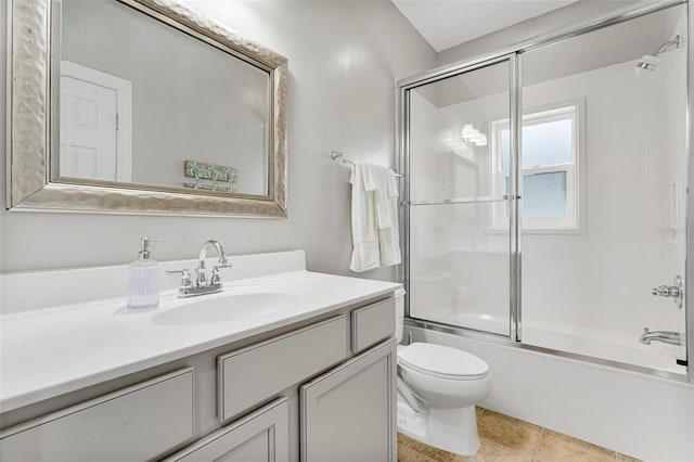 full bathroom with shower / bath combination with glass door, tile patterned flooring, toilet, and vanity