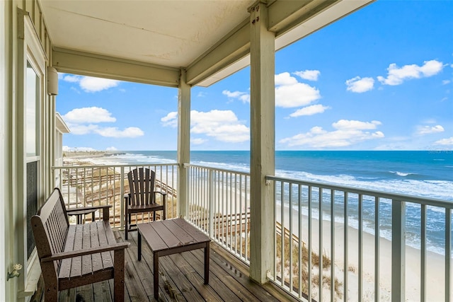 balcony featuring a beach view and a water view