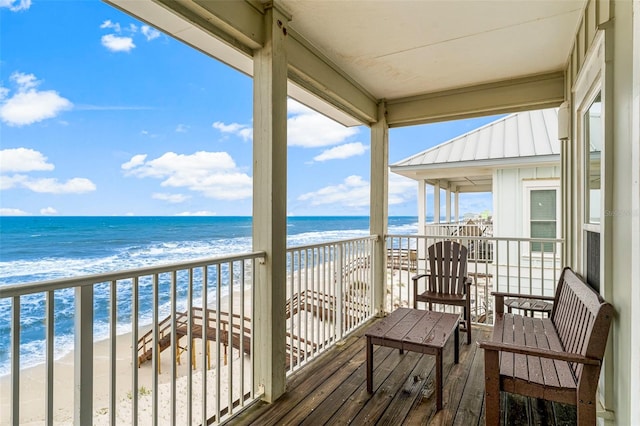balcony featuring a beach view and a water view