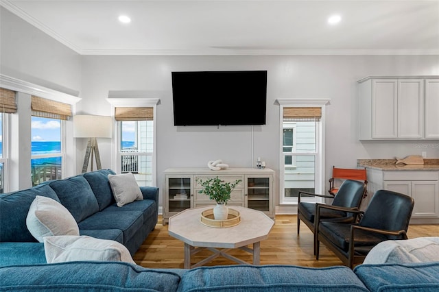 living room with recessed lighting, crown molding, and light wood finished floors