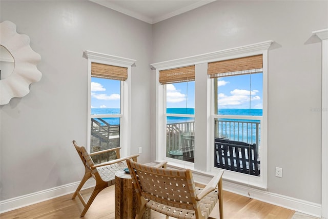 dining area featuring baseboards, ornamental molding, wood finished floors, and a water view