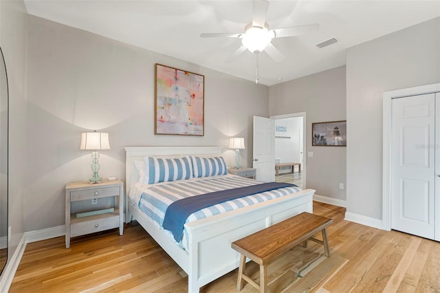 bedroom with baseboards, a ceiling fan, light wood-style floors, and visible vents