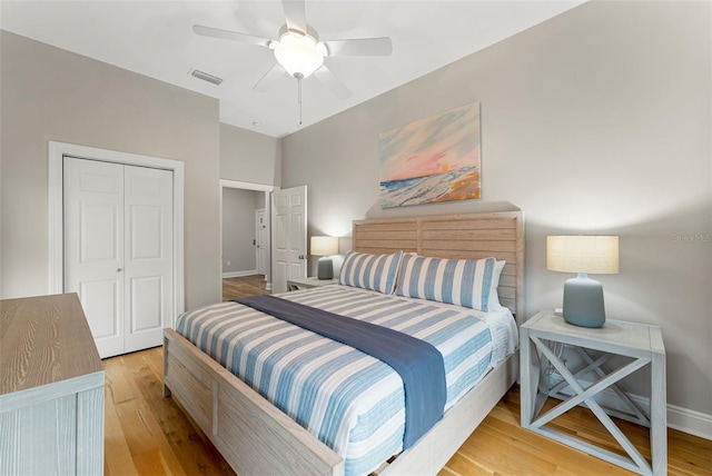 bedroom featuring a closet, light wood-type flooring, ceiling fan, baseboards, and visible vents