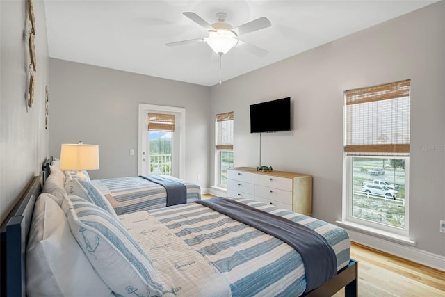 bedroom with light wood-style floors, access to exterior, baseboards, and ceiling fan
