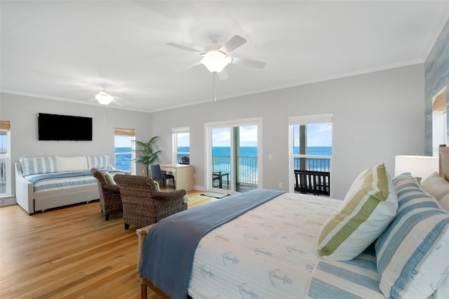 bedroom with multiple windows, light wood finished floors, ornamental molding, and access to exterior