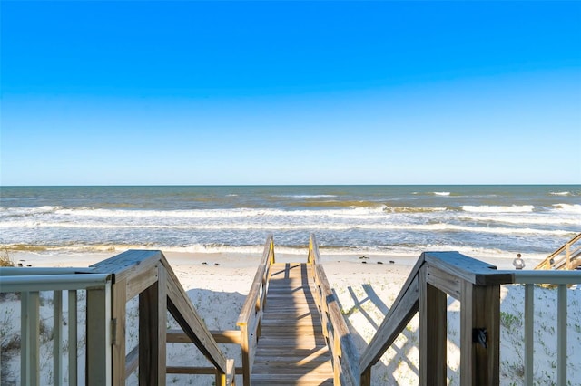 view of community featuring a beach view and a water view