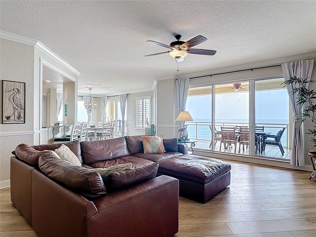 4071 S Atlantic Ave Unit 803, New Smyrna Beach, FL 32169 - living area with crown molding, a ceiling fan, a textured ceiling, light wood-type flooring, and a textured wall