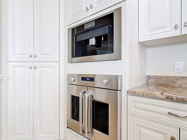 4071 S Atlantic Ave Unit 803, New Smyrna Beach, FL 32169 - kitchen with oven, decorative backsplash, light stone counters, and white cabinetry
