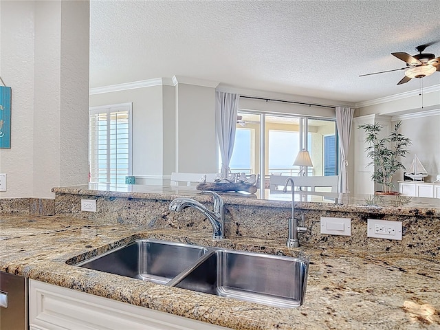 4071 S Atlantic Ave Unit 803, New Smyrna Beach, FL 32169 - kitchen with a sink, ornamental molding, a ceiling fan, a textured ceiling, and light stone counters
