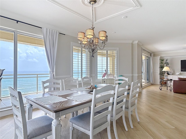 4071 S Atlantic Ave Unit 803, New Smyrna Beach, FL 32169 - dining space featuring a chandelier, a water view, crown molding, and light wood-style floors