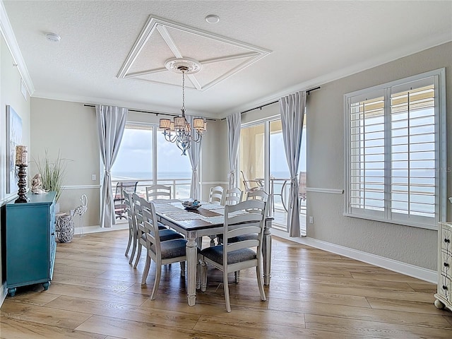 4071 S Atlantic Ave Unit 803, New Smyrna Beach, FL 32169 - dining area featuring a chandelier, plenty of natural light, light wood-type flooring, ornamental molding, and a textured ceiling