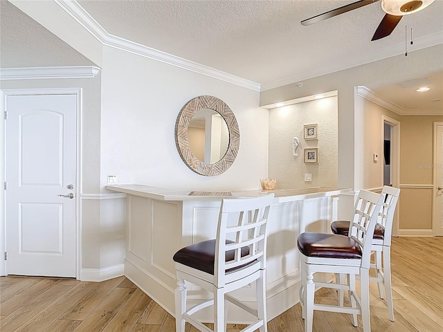 4071 S Atlantic Ave Unit 803, New Smyrna Beach, FL 32169 - bar area with ceiling fan, light wood-style floors, a textured ceiling, and ornamental molding