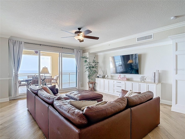4071 S Atlantic Ave Unit 803, New Smyrna Beach, FL 32169 - living room featuring a textured ceiling, ceiling fan, light wood-type flooring, baseboards, and crown molding