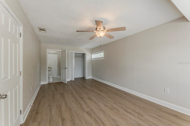 unfurnished bedroom with light wood-style floors, baseboards, a closet, and visible vents