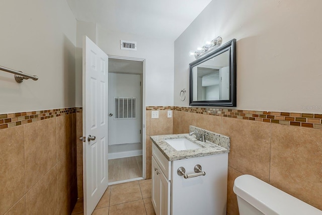 bathroom featuring visible vents, tile walls, and tile patterned flooring