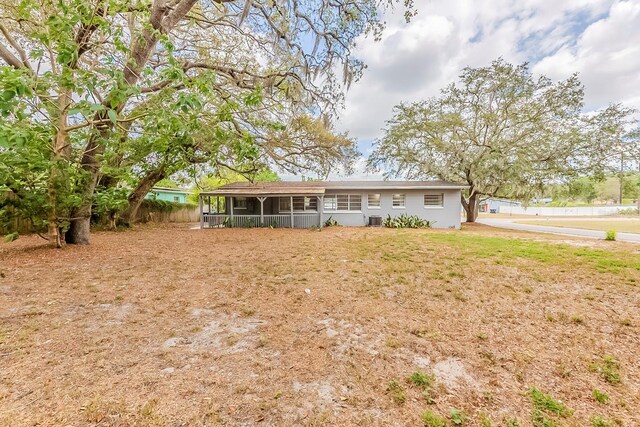 back of property featuring a lawn and a sunroom