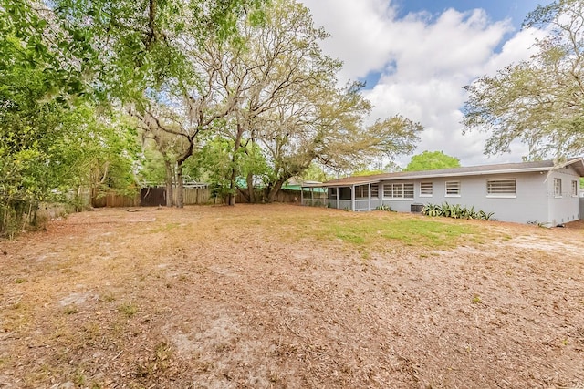 view of yard with a sunroom and a fenced backyard