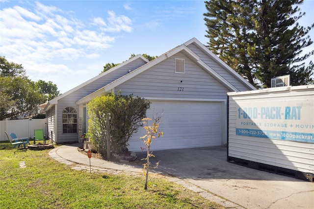 exterior space featuring a garage, a lawn, fence, and concrete driveway