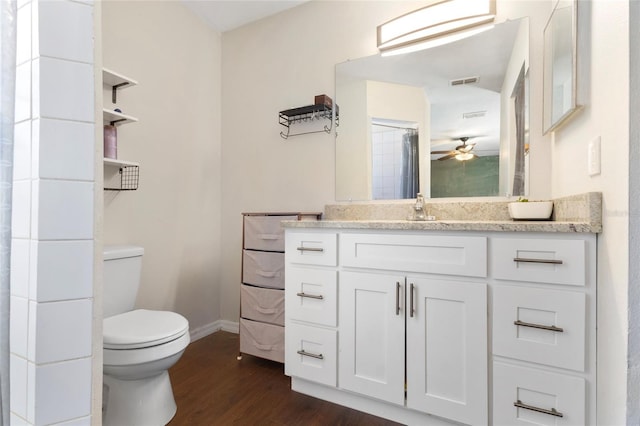 bathroom with wood finished floors, visible vents, toilet, baseboards, and ceiling fan