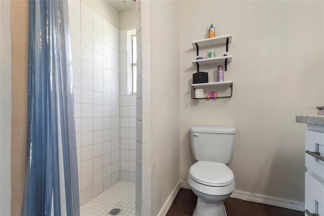 full bath featuring vanity, baseboards, a shower stall, and toilet