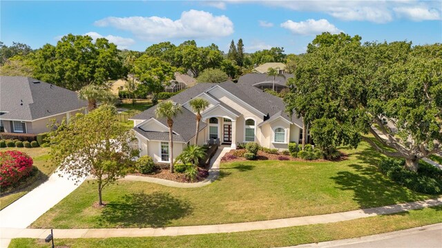 single story home with a front yard, driveway, stucco siding, and french doors