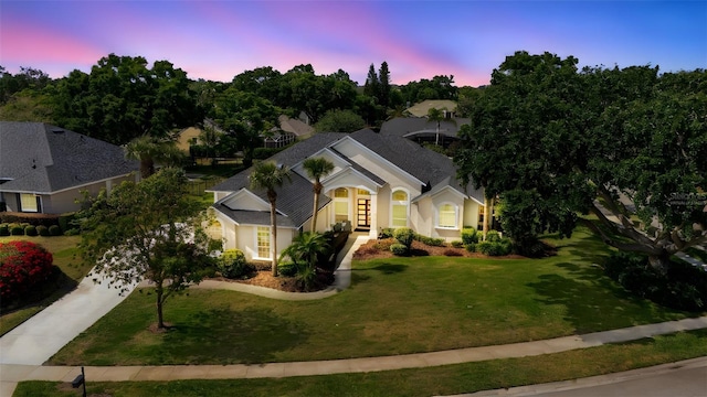 11401 Willow Stowe Ln, Windermere, FL 34786 - view of front facade with driveway, french doors, a lawn, stucco siding, and roof with shingles