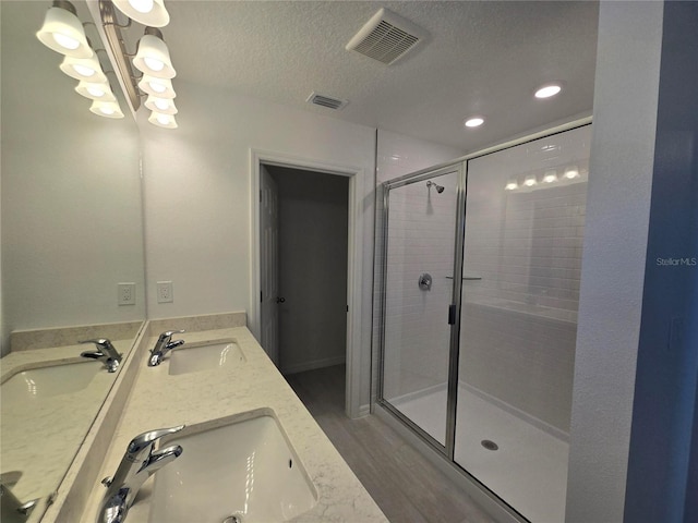full bath with visible vents, a sink, and a stall shower