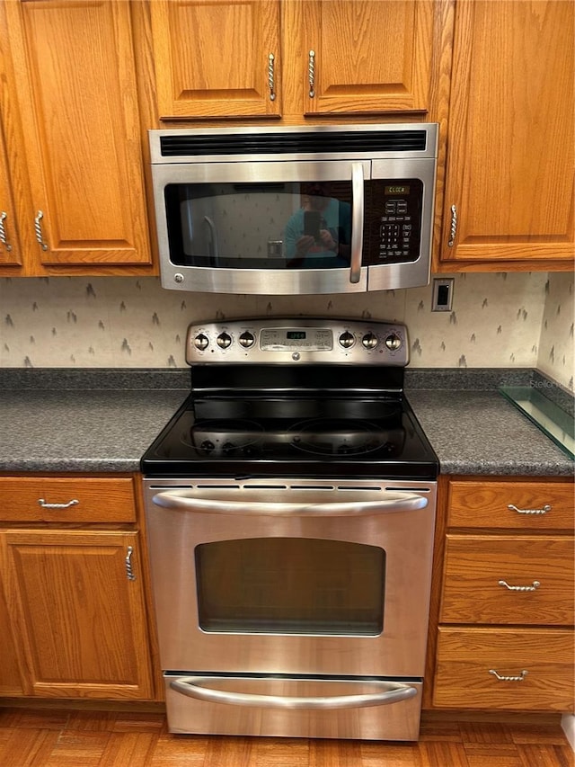 802 Park Lake Cir Unit 2, Maitland, FL 32751 - kitchen with stainless steel appliances, brown cabinetry, and dark countertops