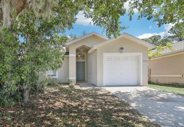 single story home with a garage, driveway, and stucco siding
