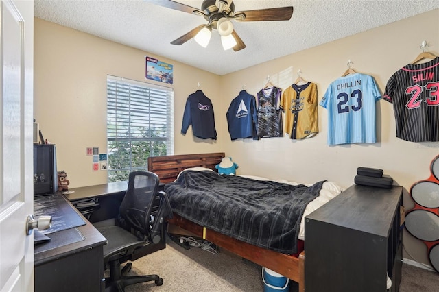 bedroom with a textured ceiling, carpet flooring, and ceiling fan