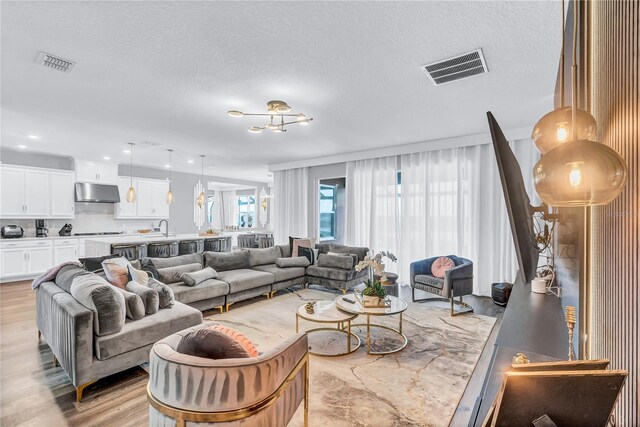 2926 Crest Wave Dr, Clermont, FL 34711 - living area with light wood-style floors and a textured ceiling