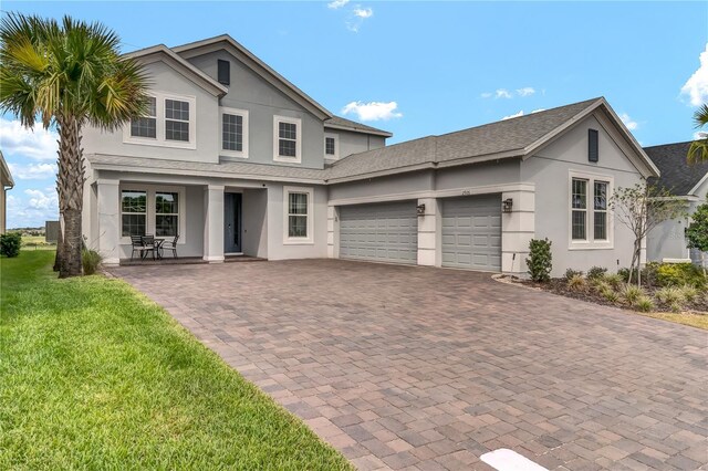 2926 Crest Wave Dr, Clermont, FL 34711 - traditional-style home featuring a garage, stucco siding, decorative driveway, a front yard, and a shingled roof