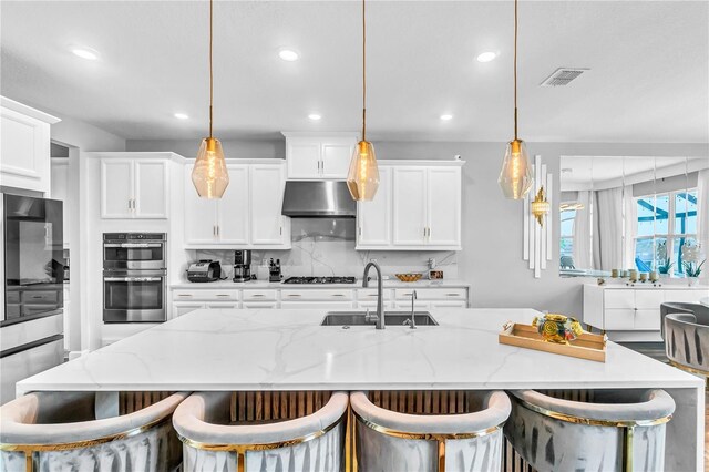 2926 Crest Wave Dr, Clermont, FL 34711 - kitchen with a sink, recessed lighting, tasteful backsplash, a center island with sink, and under cabinet range hood
