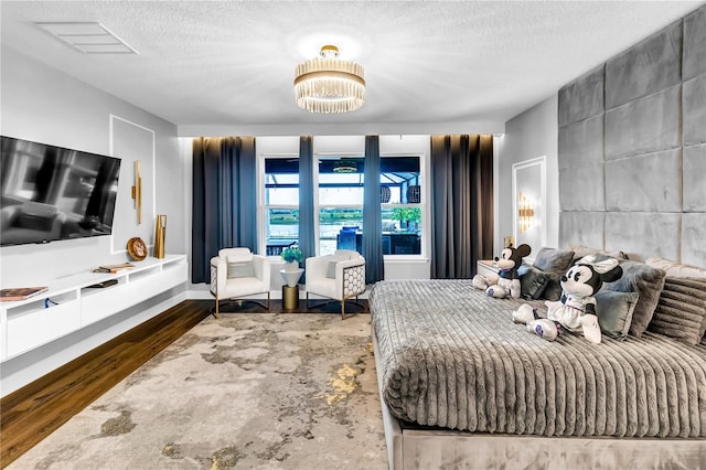 2926 Crest Wave Dr, Clermont, FL 34711 - bedroom featuring a textured ceiling, a chandelier, and wood finished floors