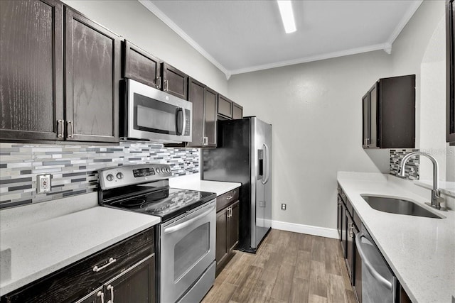 13500 Turtle Marsh Loop Unit 834, Orlando, FL 32837 - kitchen featuring crown molding, a sink, light wood-style floors, backsplash, and appliances with stainless steel finishes