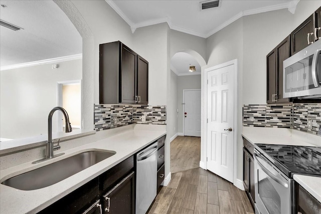 13500 Turtle Marsh Loop Unit 834, Orlando, FL 32837 - kitchen with crown molding, a sink, arched walkways, appliances with stainless steel finishes, and visible vents