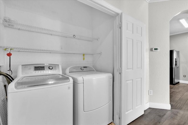13500 Turtle Marsh Loop Unit 834, Orlando, FL 32837 - clothes washing area with arched walkways, washer and clothes dryer, wood finished floors, laundry area, and ornamental molding