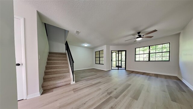 607 Northbridge Dr, Altamonte Springs, FL 32714 - unfurnished living room featuring light wood finished floors, baseboards, visible vents, a ceiling fan, and stairs