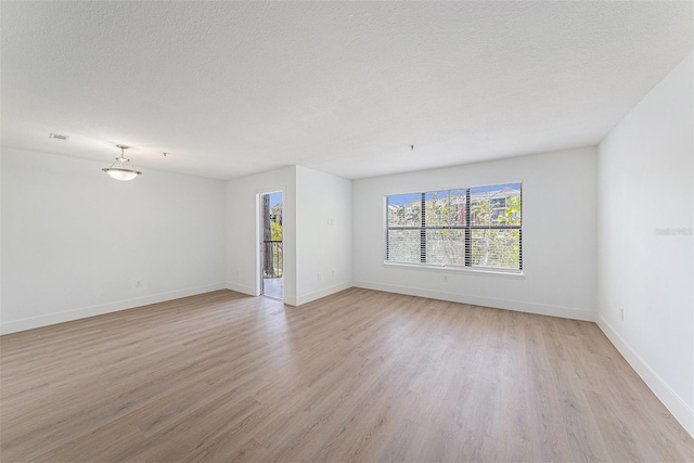 11901 4th St N Unit 2107, Saint Petersburg, FL 33716 - empty room with light wood-style floors, baseboards, and a textured ceiling