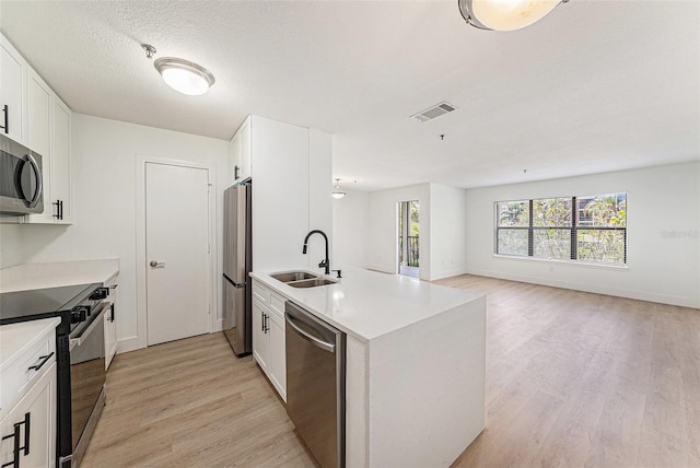 11901 4th St N Unit 2107, Saint Petersburg, FL 33716 - kitchen with a sink, appliances with stainless steel finishes, light wood-type flooring, white cabinetry, and a peninsula
