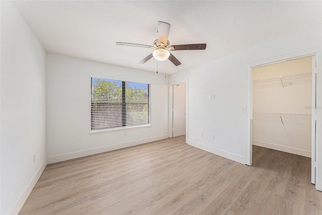 11901 4th St N Unit 2107, Saint Petersburg, FL 33716 - unfurnished bedroom featuring light wood-style flooring, baseboards, a spacious closet, and ceiling fan