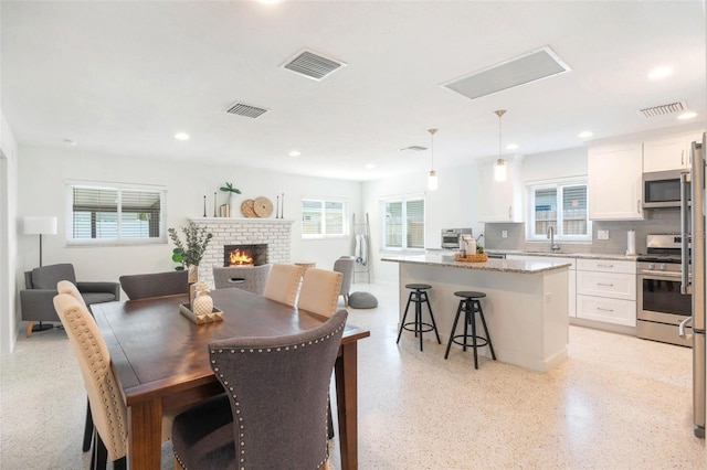 dining space with recessed lighting, visible vents, and a fireplace