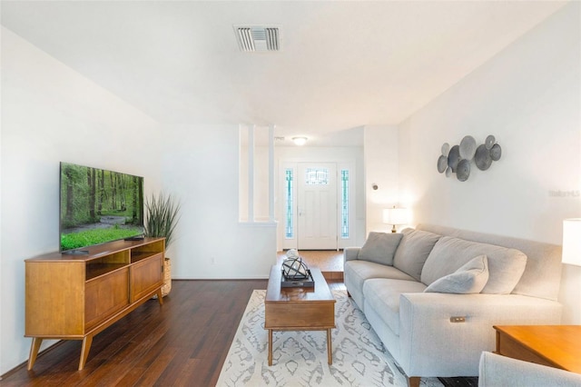 living area featuring baseboards, visible vents, and wood finished floors
